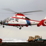 An Iceland Coast Guard (Islenska Landhelgisgaeslan) Eurocopter / Aerospatiale AS-365N Dauphin 2 (TF-SIF) Search and Rescue (SAR) Helicopter hovers over the beach as it prepares to deliver equipment to the Icelandic fishing trawler, the BALDVIN THORSTEINSSON, that ran aground on a sandbar off IcelandÕs southern coast while transporting a very valuable catch of 1,500-tons of Capelin fish.